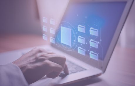 A picture of a hand typing on a computer. The computer has files floating around on it.